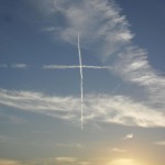 Flugzeugspuren bilden ein Kreuz am Himmel